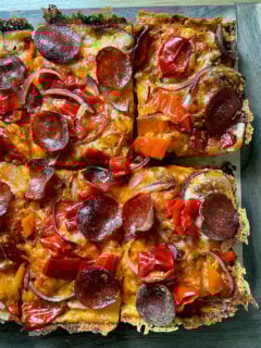 Detroit-style pizza cut into squares on a board.