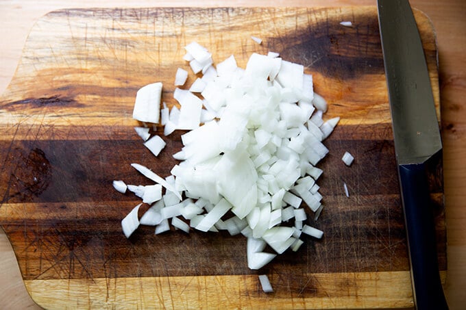 A diced onion on a cutting board. 