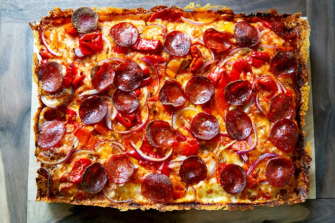 A just-baked Detroit-style pizza on a board.  - 18