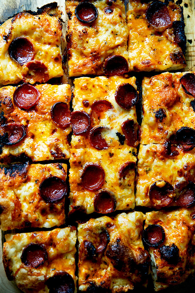 A sliced pepperoni Detroit-style pizza on a board.