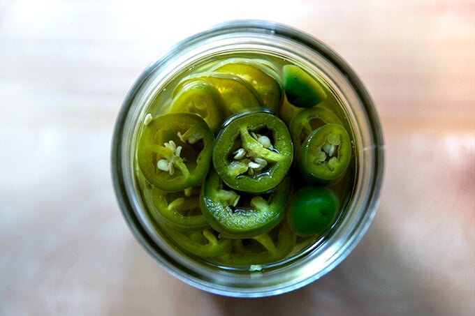 An overhead shot of pickled jalapeños in a jar.