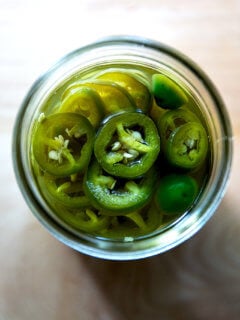 An overhead shot of a jar of pickled jalapeños.