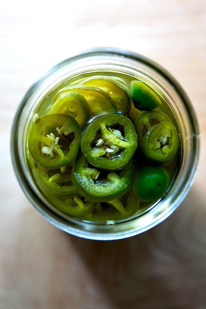 An overhead shot of a jar of pickled jalapeños.