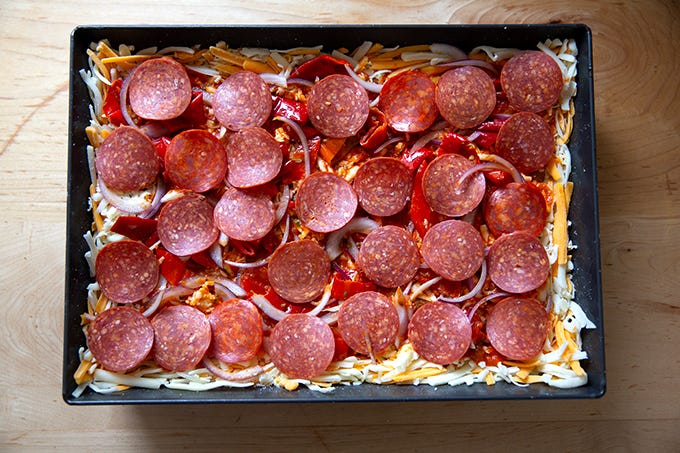 An unbaked Detroit-style pizza, ready for the oven. - 16