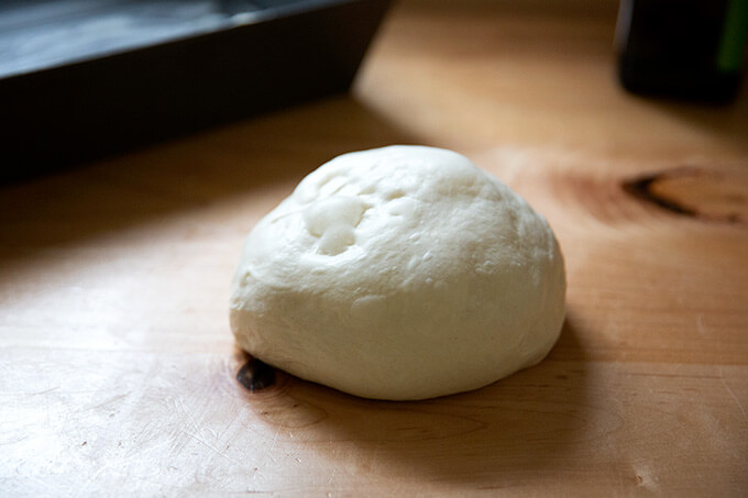 A ball of yeasted Detroit style pizza dough on the counter top.