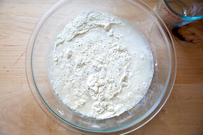 Adding the water to the dry ingredients to make focaccia.