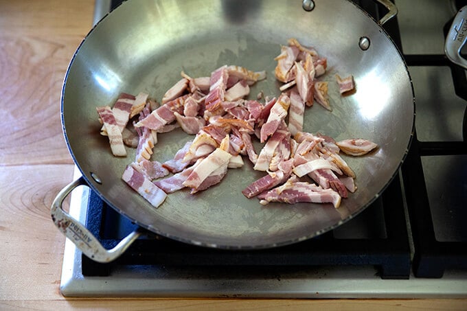 Diced bacon in a skillet.