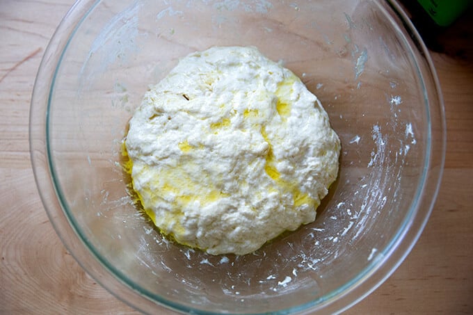 A bowl of olive oil coated dough.