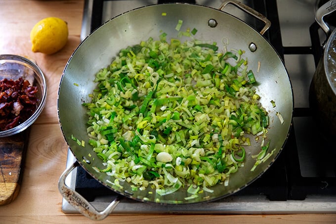 Sautéed leeks in a skillet on the stovetop.