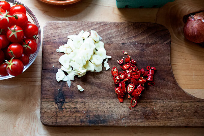 Sliced garlic and chilies on a cutting board.