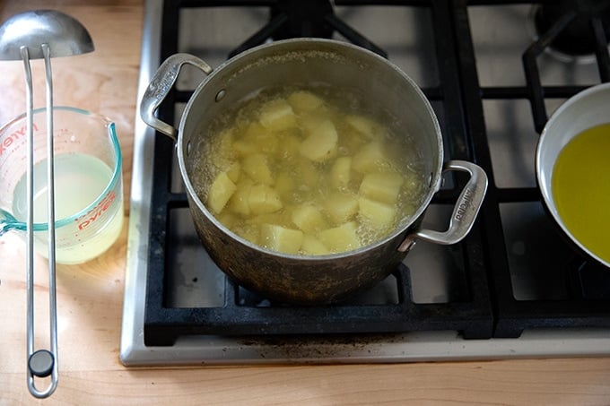 Yukon Gold potatoes boiling in a pot on the stovetop.