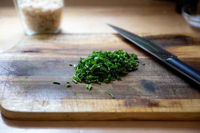 Chopped chives on a cutting board.