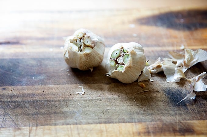 Two heads of garlic on a board. 