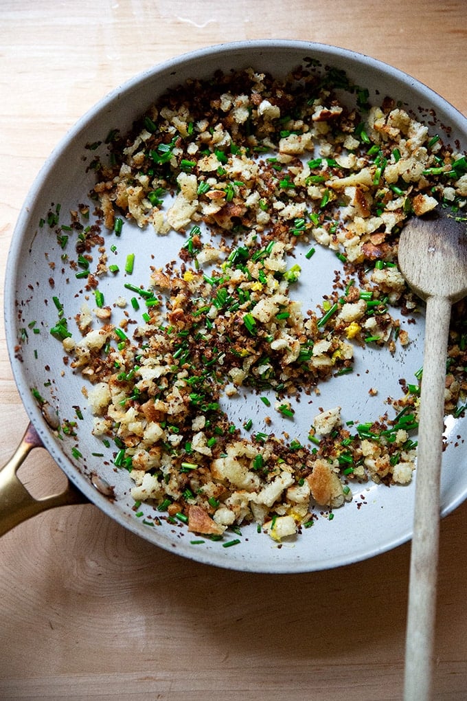 A large skillet holding gremolata bread crumbs.