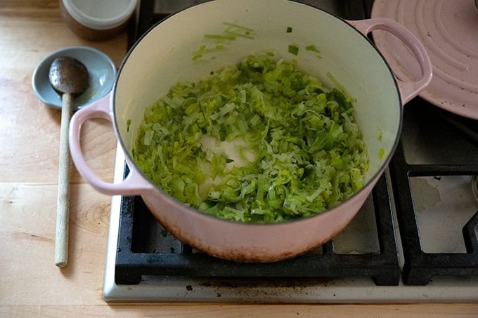 Leeks cooked down in a large soup pot.