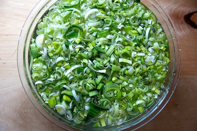 A large bowl of leeks soaking in water.