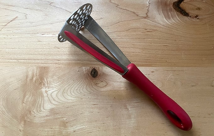 A potato masher on a countertop.