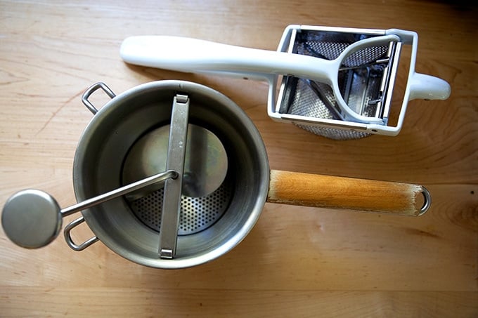 A food mill and a ricer on the stovetop.