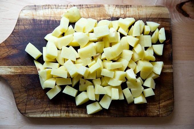 Peeled and diced Yukon Gold potatoes on a board.