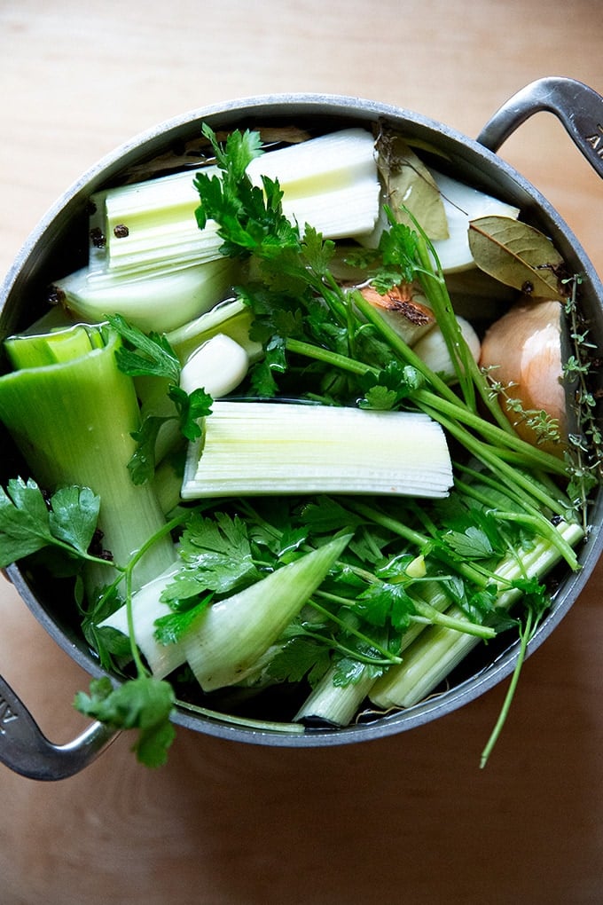 A soup pot holding vegetables to make vegetable stock.