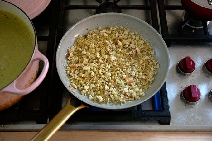 A skillet holding bread crumbs on the stovetop.