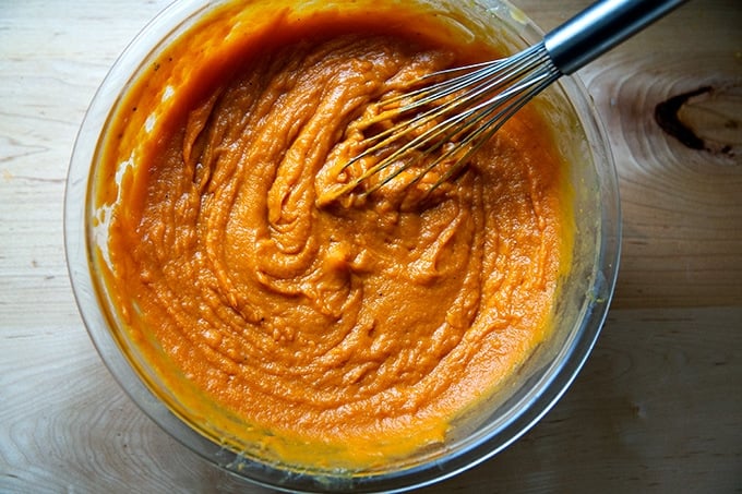 Sweet potato filling in a large bowl with a whisk.