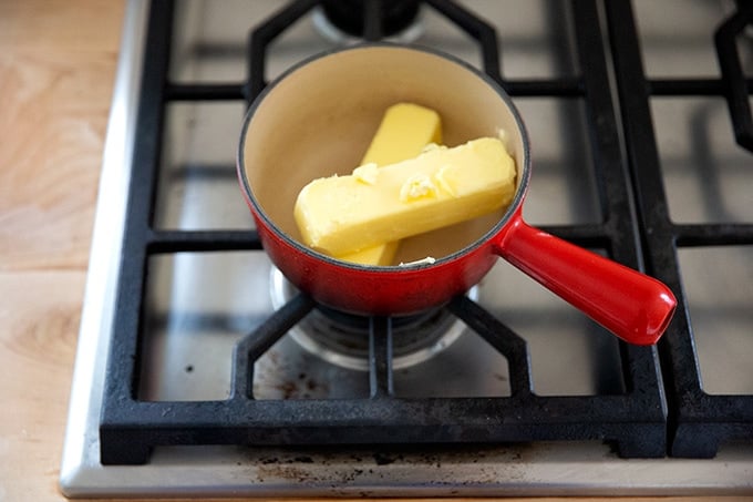 Two sticks of butter in a sauce pan on the stovetop.