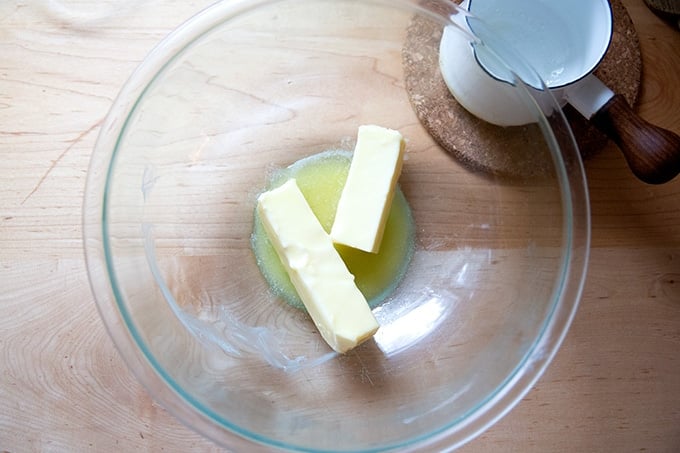 A bowl of softened butter and a small amount of melted butter.