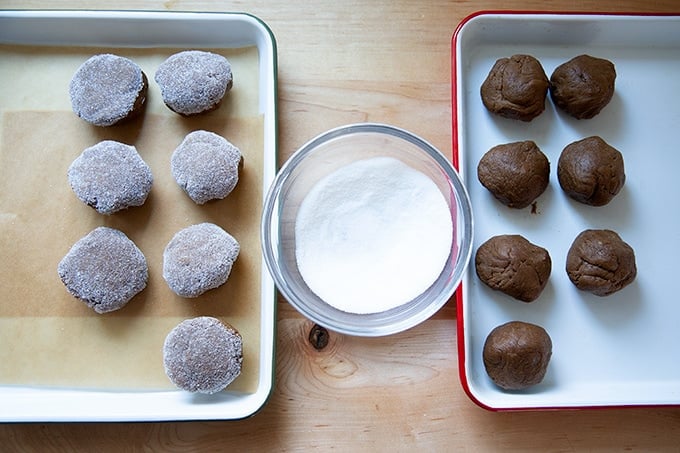 Rolling molasses cookie dough balls in sugar.