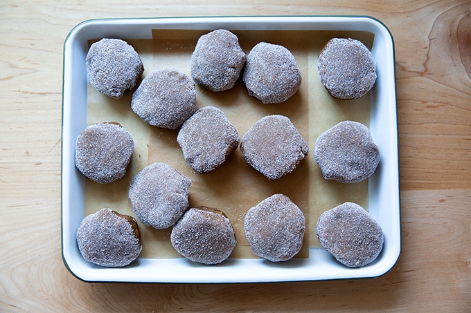 Unbaked molasses cookies on a tray.