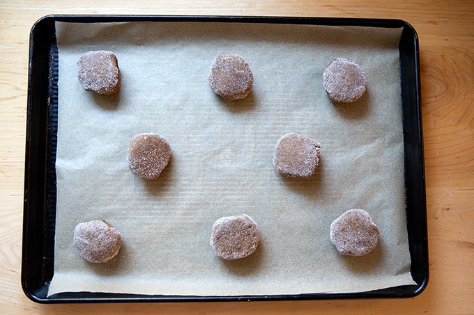 Unbaked molasses cookies on a sheet pan.