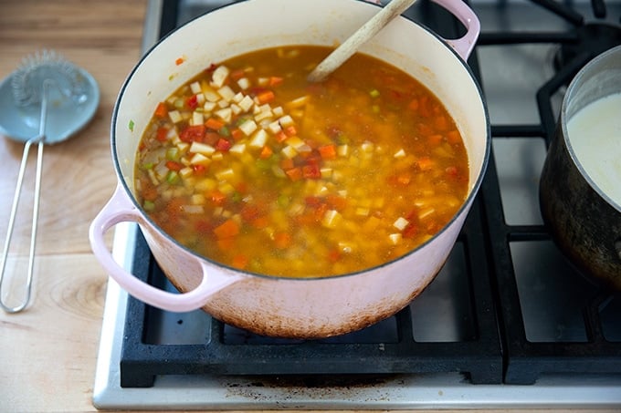 A large pot of vegetables and vegetable stock simmering on the stovetop.