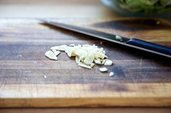 Sliced garlic on a board.