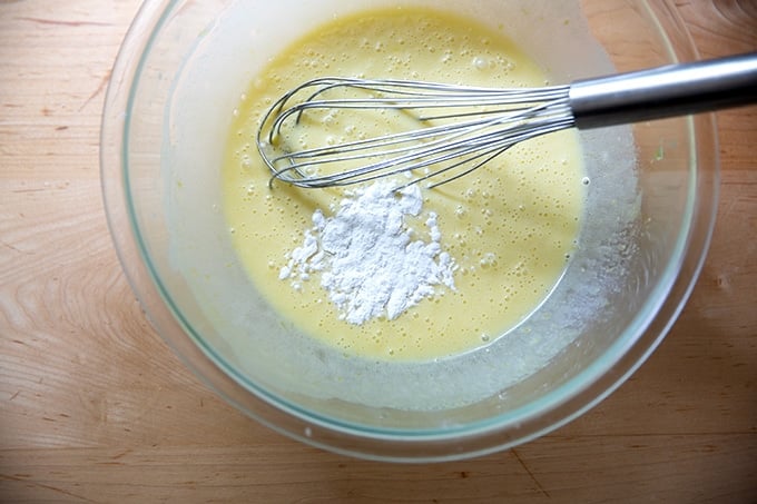 A bowl of partially mixed lemon-blueberry quick bread batter with the baking powder just added.