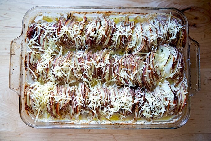 Hasselback potato gratin after 60 minutes in the oven, covered with grated cheese.