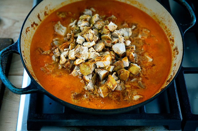 A braiser on the stovetop filled with butter chicken.