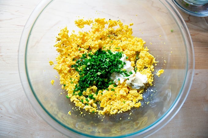 A bowl of mashed hard-cooked yolks, chives, mayo, mustard, and pickle juice.