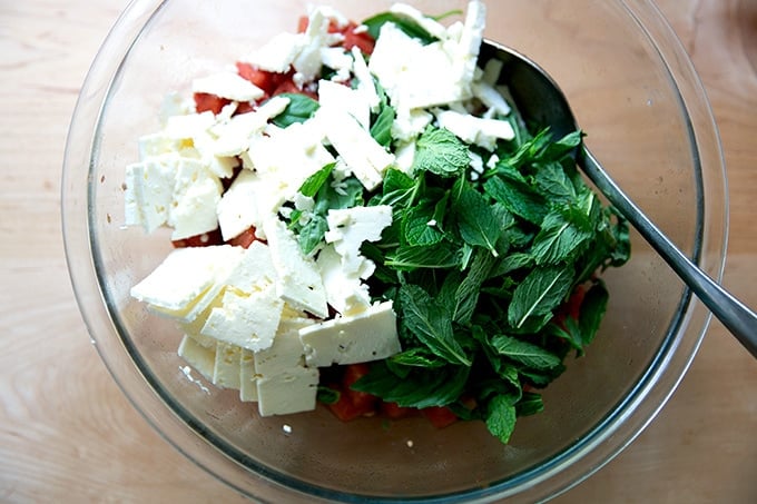 A bowl of cubed watermelon, feta, and herbs.