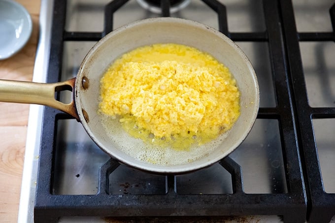 A skillet with fresh corn polenta cooking in it.