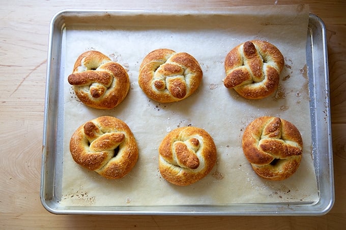 Just-baked soft pretzels on a sheet pan.