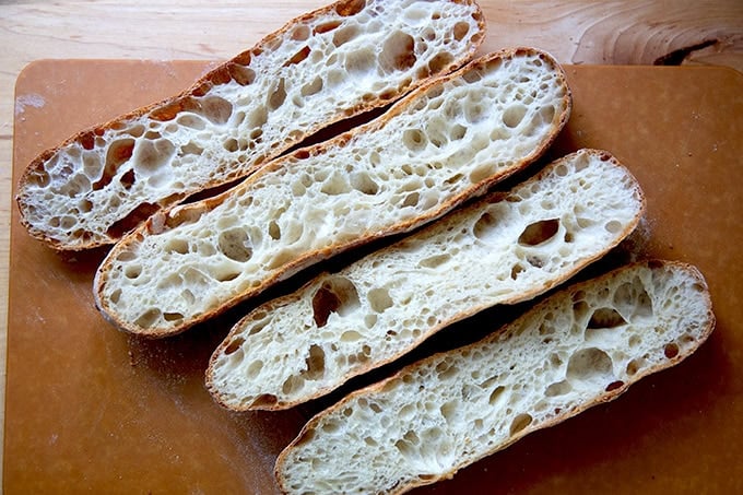 Two halved baguettes on a cooling rack.