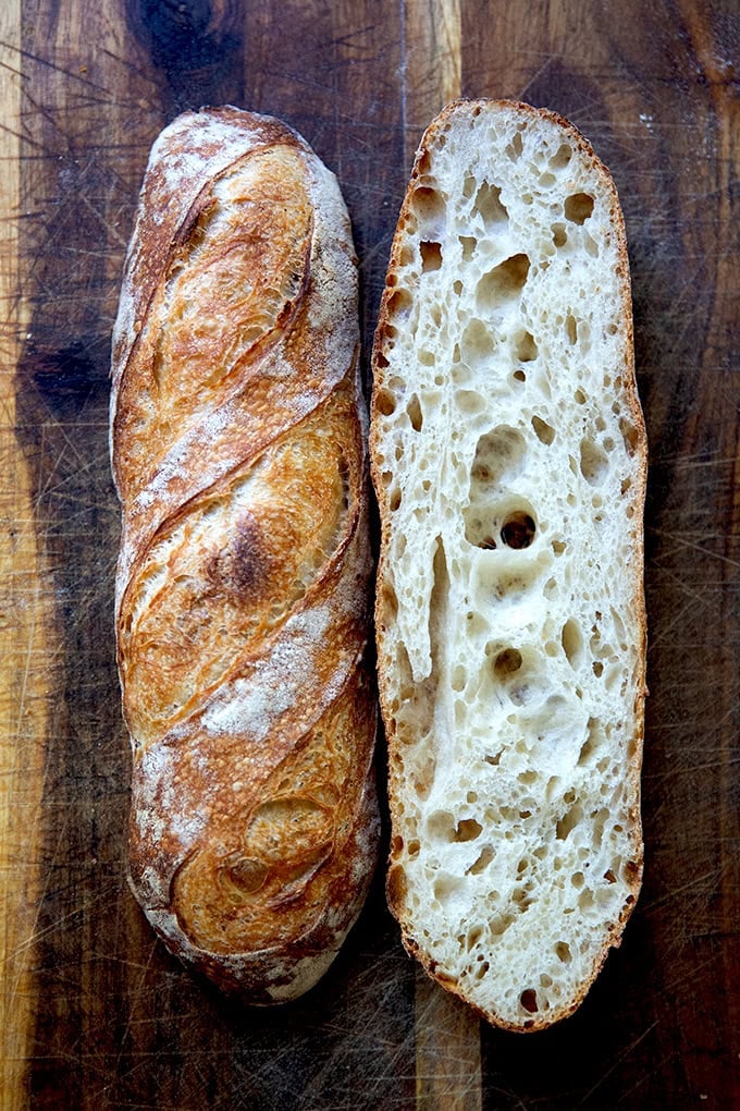 A halved baguette on a cutting board.