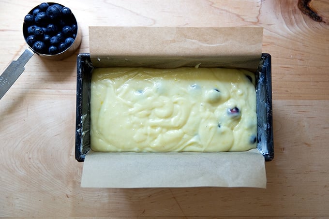 A loaf pan filled with lemon-blueberry quick bread batter.
