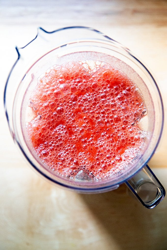An overhead shot of a blender filled with strawberry Paloma slushies. 