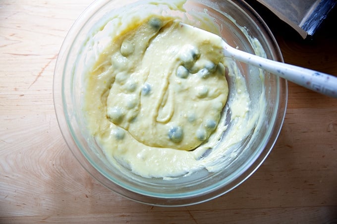 A bowl of mixed lemon-blueberry quick bread batter with the blueberries.