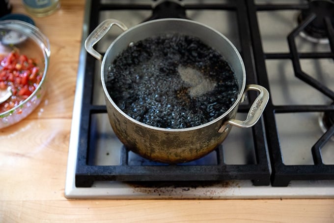 A pot of lentils boiling stovetop.