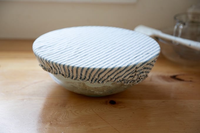 A mixing bowl covered with a cloth bowl cover.