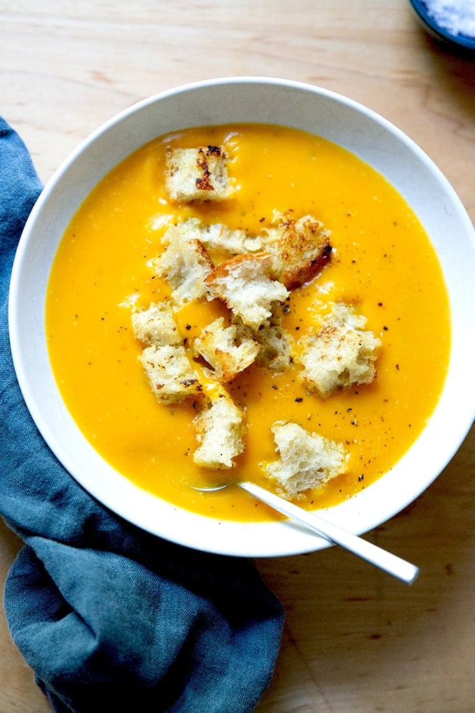 A bowl of roasted butternut squash soup topped with croutons.