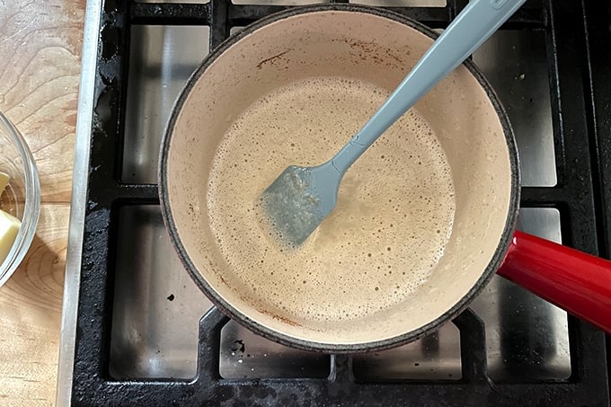Brown butter in a skillet on the stovetop with a spatula.