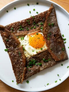 A plate topped with an egg-and-gruyere filled buckwheat crepe.